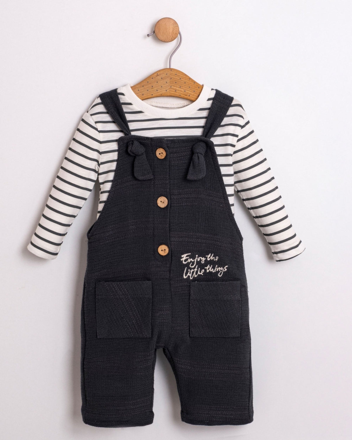 Baby boy navy dungarees with tie straps over a striped long-sleeve top, front view