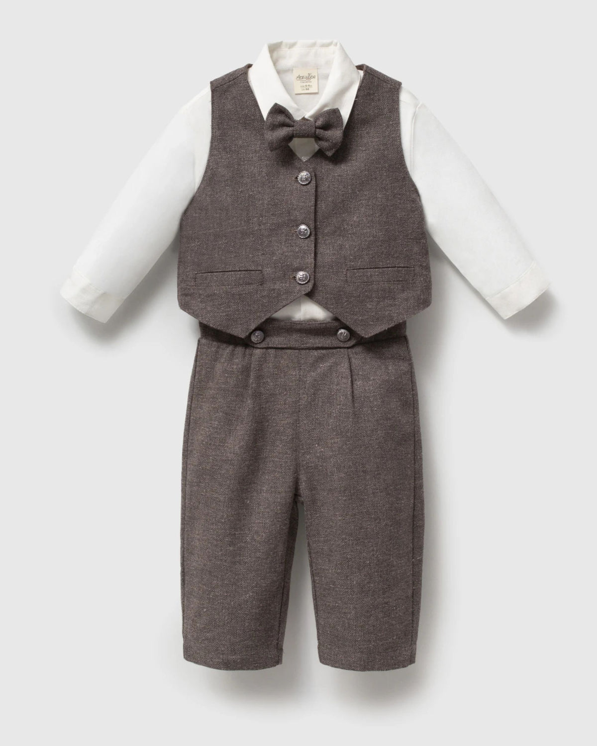 Baby boy standing in a brown waistcoat suit and bow tie at a garden wedding