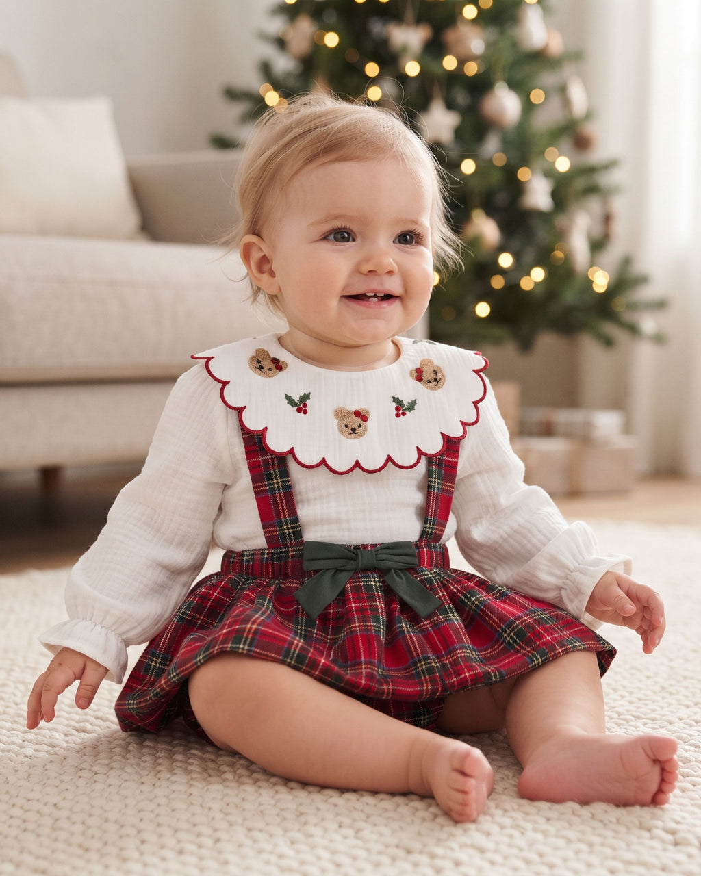Baby girl Christmas outfit with ivory teddy-collar blouse and red tartan romper, front view on hanger