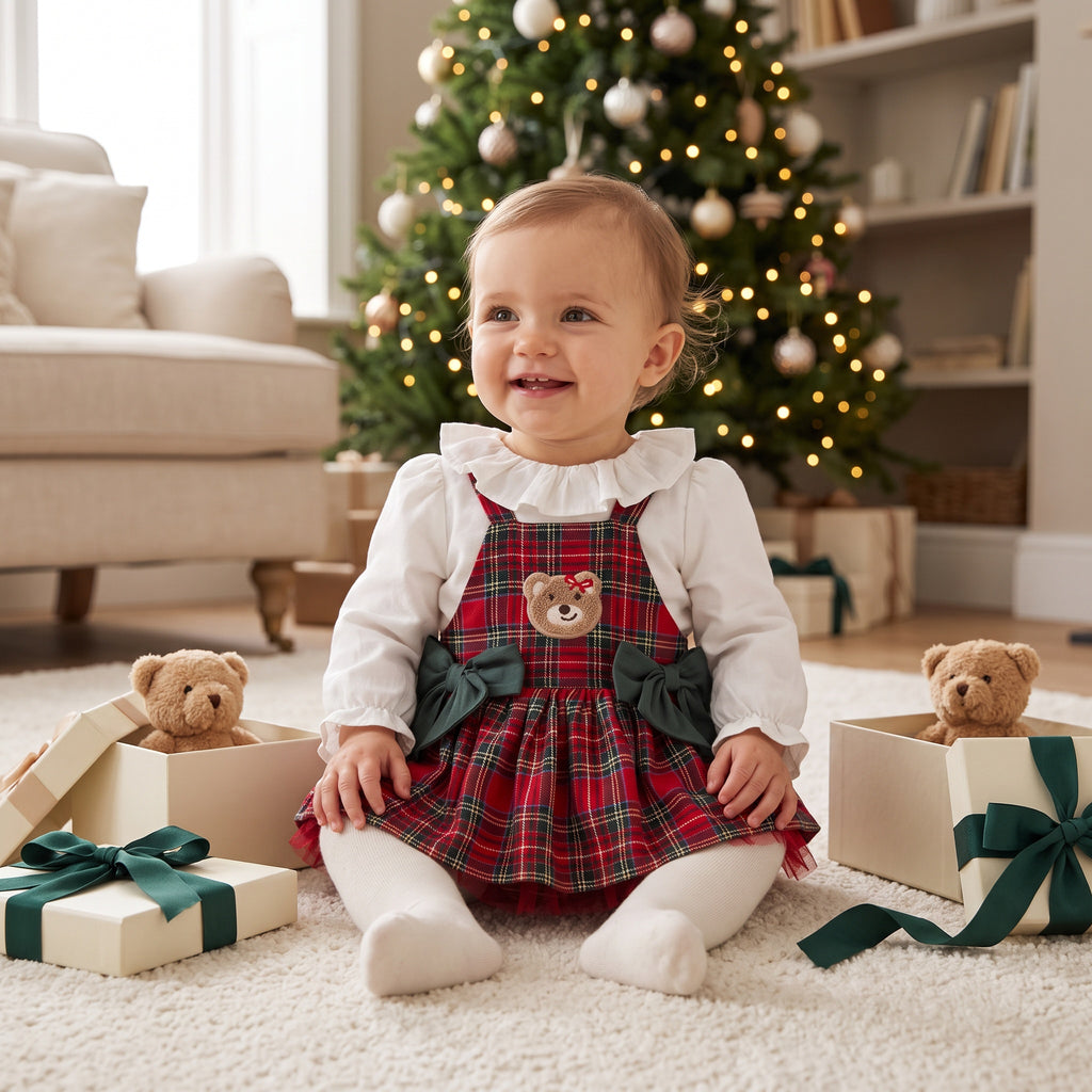 Baby girl tartan pinafore romper with teddy appliqué and green bows over ivory blouse, front view