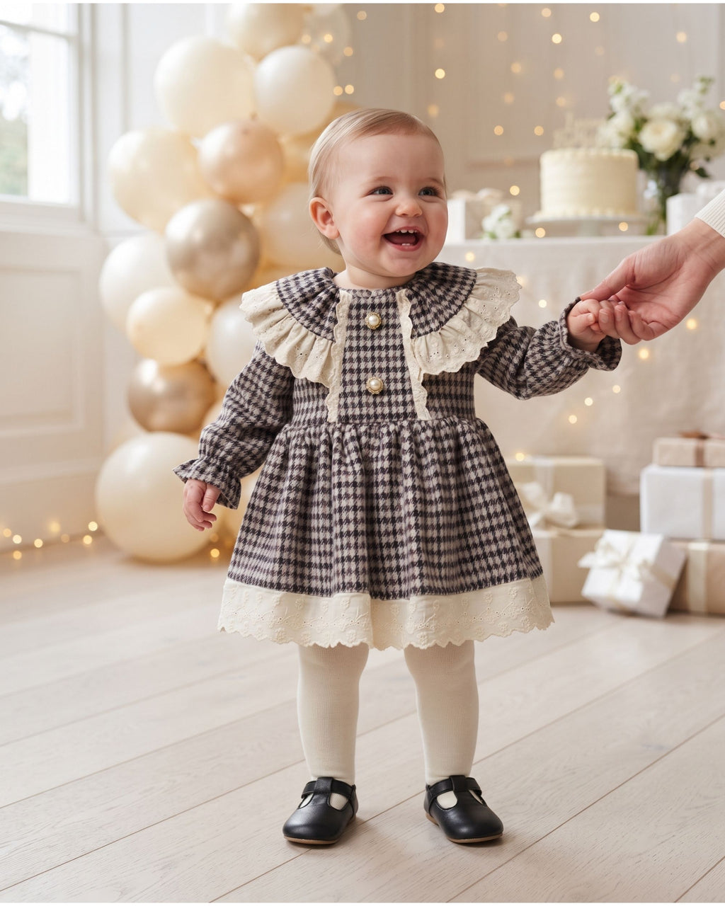 Baby girl wearing a houndstooth dress with lace collar at a family celebration