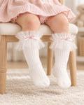 Baby girl sitting in a party dress and white tulle frill knee socks