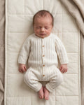 Ribbed sleeve cuff on a cream knitted cotton baby romper