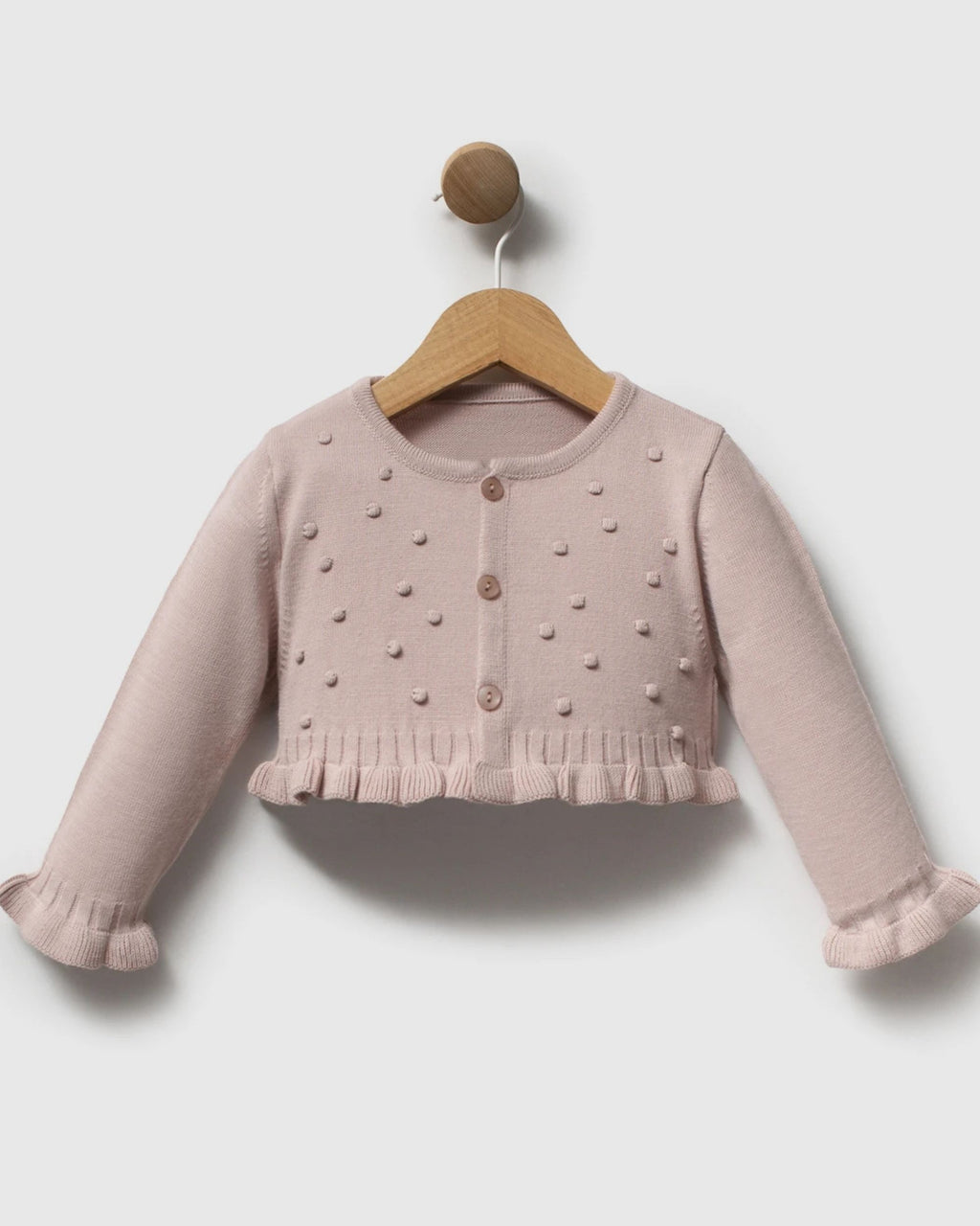 Pink gingham romper dress and knit cardigan laid flat with a christening card