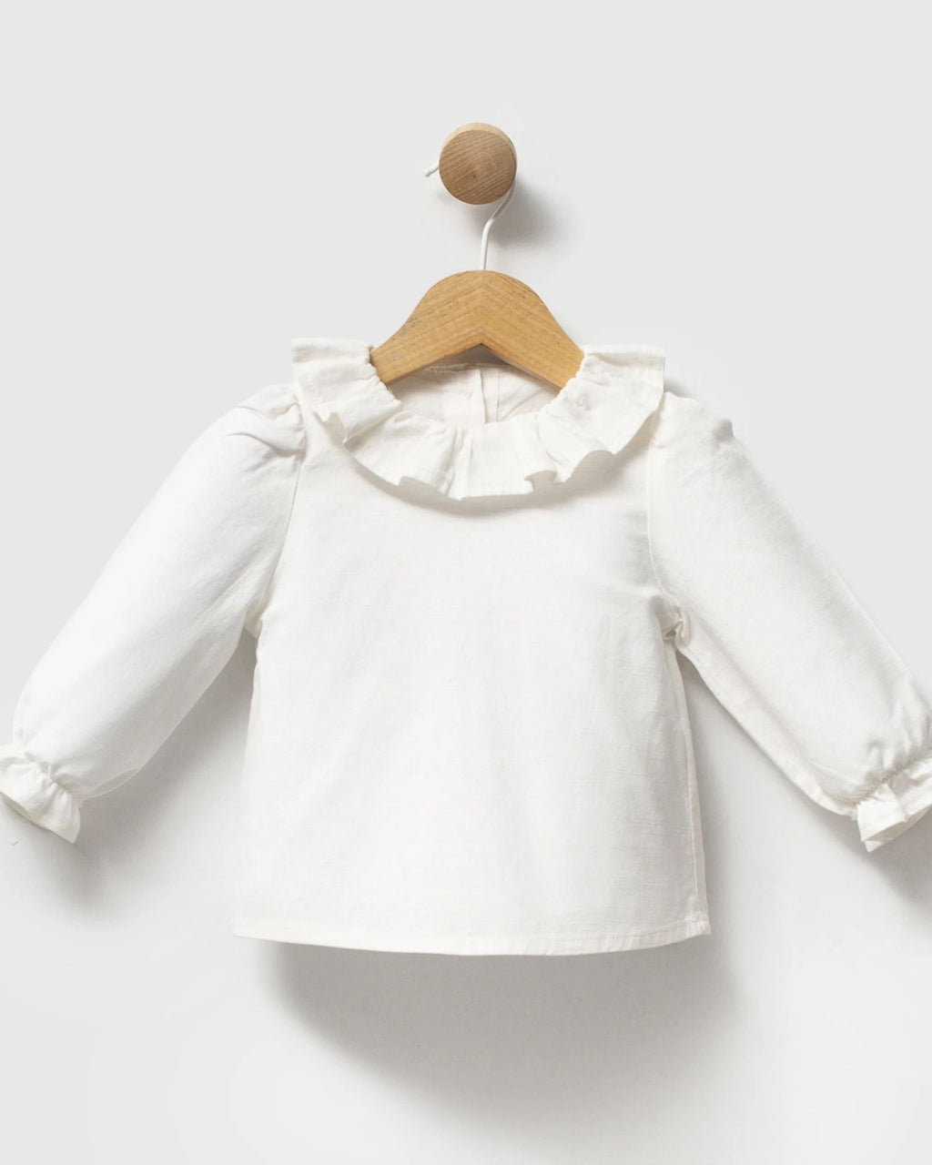 Ivory baby blouse with ruffled collar and frilled cuffs