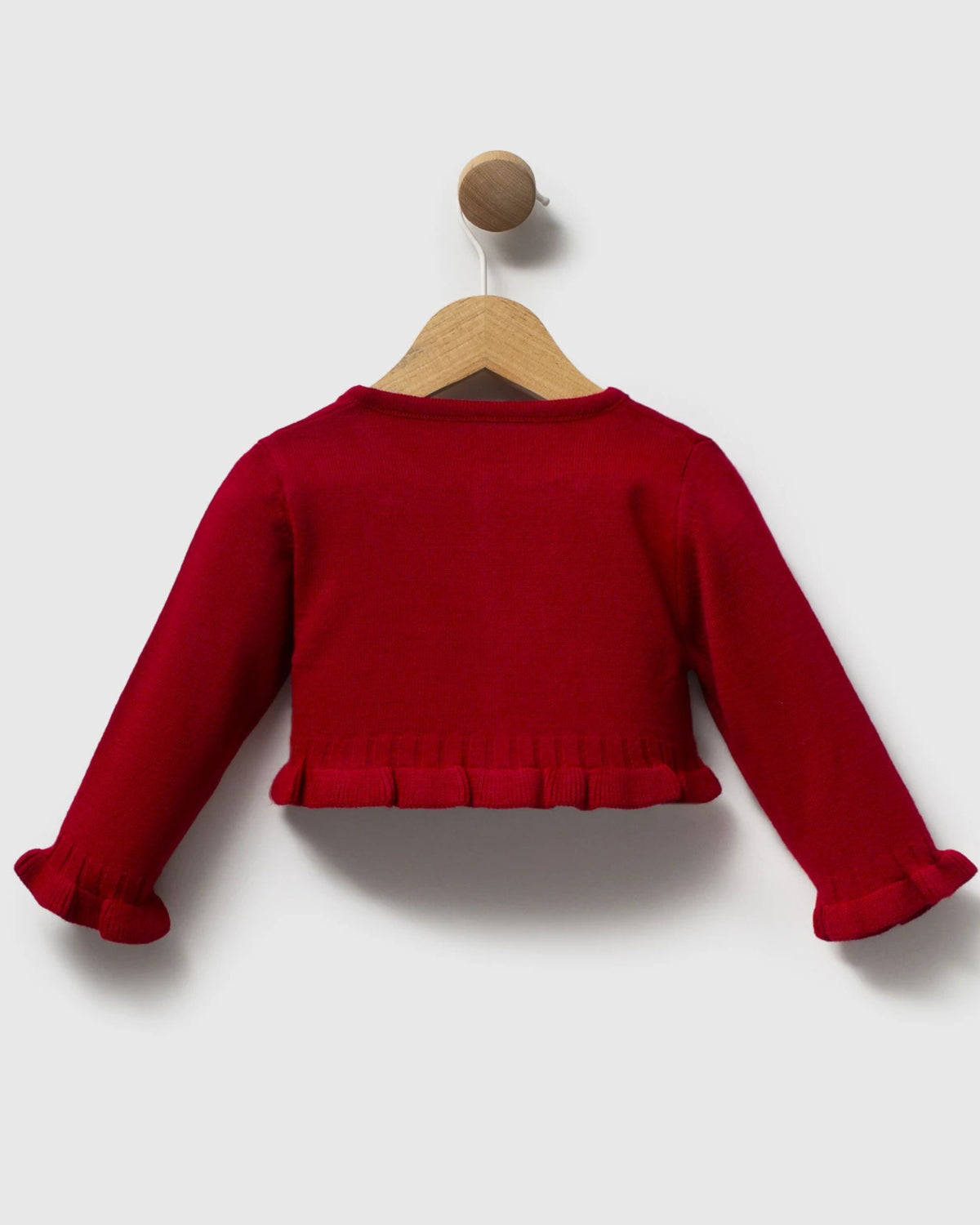 A bright red long-sleeve knit top for toddlers, featuring a ruffled hem and ruffled cuffs, displayed on a wooden hanger against a light gray background.