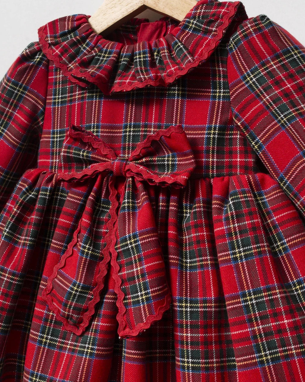 Close-up of frilled collar with red trim on a tartan baby dress
