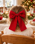 Toddler girl wearing a red bow hair clip at Christmas